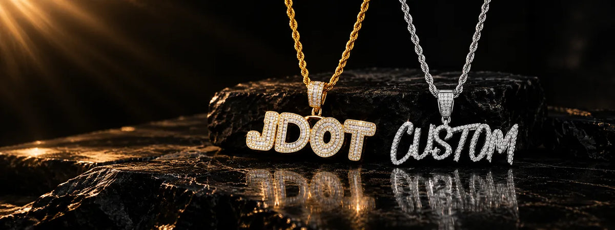 Custom name necklaces with iced-out diamond letters — "JDOT" in gold bubble font and "CUSTOM" in silver script, on rope chains