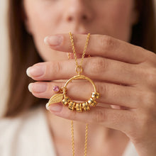 Load image into Gallery viewer, Gold circle pendant necklace with custom name beads and a leaf charm