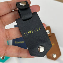 Load image into Gallery viewer, Black leather photo keychain with FOREVER stamped in gold, held in hand