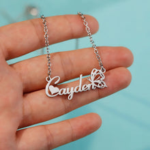 Load image into Gallery viewer, Hand holding a silver butterfly script name necklace on a blue background