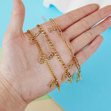Load image into Gallery viewer, Hand holding several gold dangling letter necklaces with different names