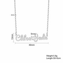 Load image into Gallery viewer, Size chart for the iced out double name necklace: 49 mm wide, 13 mm tall, 5 mm CZ heart, 2 mm chain, 5.8 g