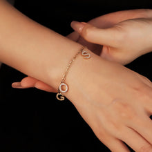 Load image into Gallery viewer, Woman wearing a custom multiple initial bracelet with gold CZ letter charms