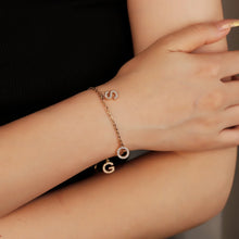Load image into Gallery viewer, Close-up of a gold family initial bracelet worn on the wrist