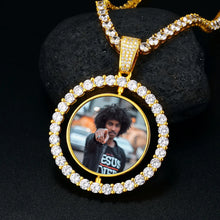 Load image into Gallery viewer, Gold spinning medallion necklace on a CZ tennis chain resting on a black stone