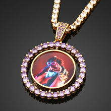 Load image into Gallery viewer, ront view of the yellow gold colorful custom double-sided rotating pendant with purple stones, paired with a sparkling tennis chain.