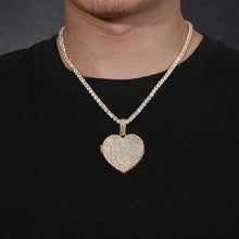 Load image into Gallery viewer, A model wearing the iced-out yellow gold personalized heart photo locket necklace on a chain.