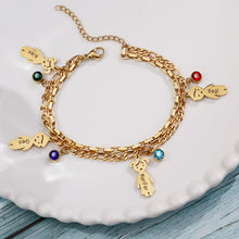 Load image into Gallery viewer, Gold boy and girl charm bracelet with names and birthstones on a white plate