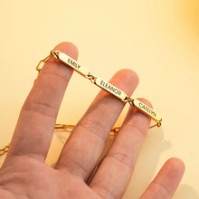 Load image into Gallery viewer, Hand holding a gold custom name bracelet to show the engraved bar links up close