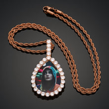 Load image into Gallery viewer, Rose gold plated GetEngravings custom teardrop photo pendant attached to a matching rope chain against a dark background.