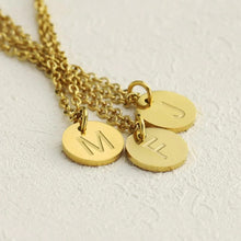Load image into Gallery viewer, Close-up of engraved initial disc pendants in gold-plated finish