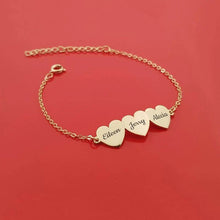 Load image into Gallery viewer, Gold family name bracelet with three engraved heart charms on red background