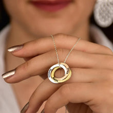 Load image into Gallery viewer, Woman's hand holding engraved name necklace showing ring detail and laser engraving